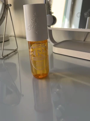 Sol de Janeiro Brazilian Crush 62 - En snygg parfymmist från Sol de Janeiro i doften Brazilian Crush Cheirosa 62. Flaskan är genomskinlig med gul vätska och har ett vitt, cylinderformat lock. Volymen är 90 ml och flaskan har en modern, stilren design.
