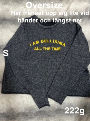 Mörkgrå oversized tröja med text - Mörkgrå oversized tröja med gul broderad text 'I AM BELLÍSIMA ALL THE TIME' på bröstet. Perfekt för en avslappnad och trendig look.🌸Har fransar upp sig lite vid ärmar och längst ner. Kortare modell ( typ crop top) Storlek s