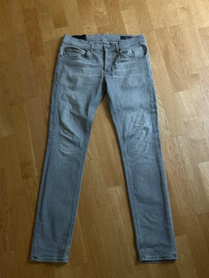 Ljusgråa Dondup George jeans - Säljer ett par ljusgråa jeans från Dondup i modellen george. Perfekt grå nyans och har en del stretch i sig så de är både bekväma och passar de flesta. 