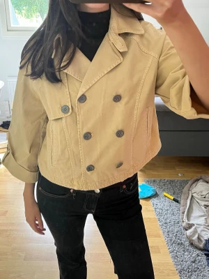 Kort beige trenchcoat med dubbelknäppning - En helt ny beige trenchcoat från Zara med prislappen kvar 