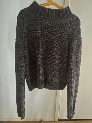 Grå stickad tröja från Divided H&M - Mysig grå stickad tröja från Divided H&M i storlek XS. Tröjan har en grovstickad struktur, ribbad hög krage samt ribbade muddar vid ärmslut och nederkant. Perfekt för lager-på-lager och en avslappnad stil.
