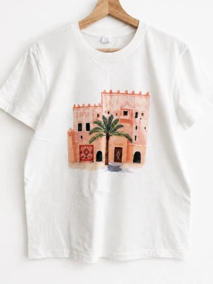Vit t-shirt med tryck av byggnad - Vit t-shirt med ett färgglatt tryck av en byggnad och palm på bröstet. Klassisk passform och rund halsringning. Perfekt för dig som gillar unika motiv och enkel stil.