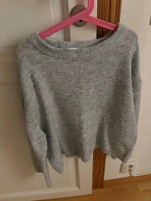 Ljusgrå stickad tröja  - Mysig ljusgrå stickad tröja från 157 med rund halsringning och ribbade muddar. Perfekt för lager på lager och enkel att matcha med olika outfits. Tröjan har en avslappnad passform och är tillverkad i mjukt material.