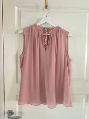 Superfin rosa topp - Söt ljusrosa blus från H&M i storlek 38. Blusen är ärmlös med rundad halsringning och knytband framtill. 💞💞💞