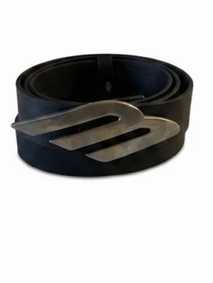 Svart bälte med unik silverspänne - Snyggt svart bälte i skinn med ett coolt, formgivet silverspänne som verkligen sticker ut. Perfekt accessoar för att lyfta din outfit med en modern touch.