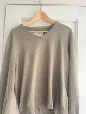 Maison margiela stickad tröja - Jag säljer denna tröja åt min mamma från maison margiela i jättefint skick. Den har läderlappar på ärmarna vilket gör att tröjan får de lilla extra!! Det finns en liten fläck på ena baksida arm men det är bara att be om bilder på den fläcken!💕💕💕