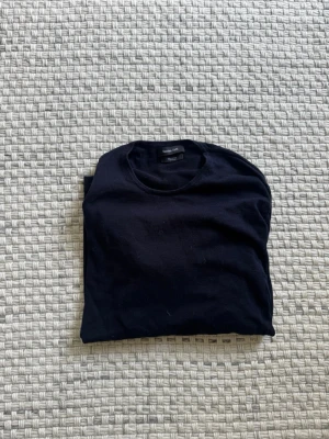 Svart t-shirt från Massimo Dutti - En stilren svart t-shirt från Massimo Dutti i 100% bomull. Klassisk rund halsringning och enkel design som passar till allt. Perfekt basplagg för garderoben.