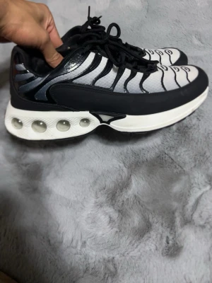 Svarta och vita futuristiska sneakers - Unika sneakers i svart och vitt med vågformade detaljer och transparenta bubblor i sulan. Ovandelen är i mesh och syntetmaterial med svarta snören och coola linjer över tån. Sulan är tjock och ger en futuristisk vibe. Perfekta för dig som vill sticka ut.Det är Inga Nike tns 