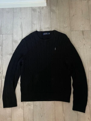 Stickad Ralph Lauren Tröja - Tja, säljer denna stickade tröja från Ralph Lauren eftersom att den inte passar mig. Storleken på tröjan är L. Bra skick med små tecken på användning!