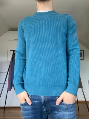 COS tröja  - Blå tröja från COS tillverkad i 100% bomull. Strl S. Taggen har lossnat från en sida (se bild 4). Modellen är 178 cm och väger 77 kg. Hör gärna av dig vid frågor!