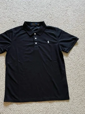 Polo Ralph lauren pike  - En svart Polo Ralph lauren pike med vit logga. Den är i storlek S och i helt nytt skick. Pris kan diskuteras och skriv om du har några frågor. 