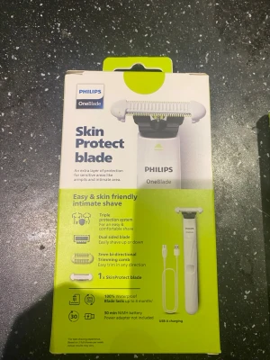 Philips OneBlade Skin Protect blad - Philips OneBlade Skin Protect blad är ett rakblad speciellt utformat för känsliga områden som armhålor och intimzon. Bladet har ett skyddande lager, dubbelsidig design och medföljer en 3 mm kam för enkel trimning. Vattentålig och laddas med USB-A.