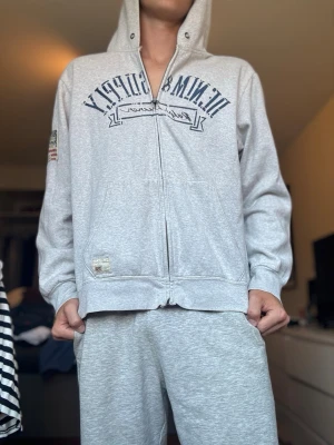 Grå Ralph lauren denim & supply hoodie  - Hoodie från Ralph lauren denim and supply, väldigt fin, storlek L och modellen är 183,73 kg. Bra skick ända är ett dragkedjan kan vara lite krånglig ibland, annars bra.