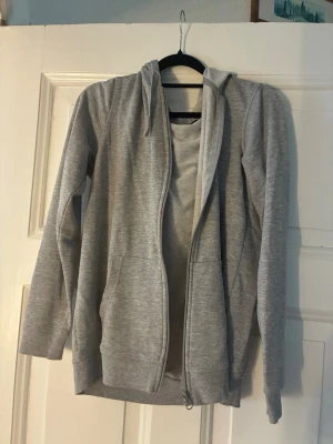 Ljusgrå zip hoodie - En grå zip hoodie som aldrig använts.