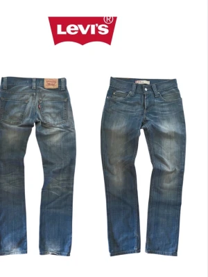 Levi's 699 blå raka jeans - Klassiska blå jeans från Levi's med rak passform och fem fickor. Jeansen har slitningar och tvättade detaljer för en avslappnad look. Tillverkade i slitstark denim med synliga sömmar och läderpatch bak i midjan.