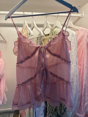 Rosa volang topp - Ljusrosa volang topp från design by Amor och använd en gång💗har knyten där fram för att få ihop tröjan.