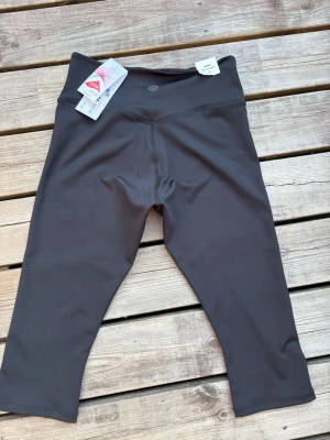 Svarta Capri - Snygga svarta caprileggings från Slazenger i mellanhög midja. Nya med prislapp kvar. Storlek S/M