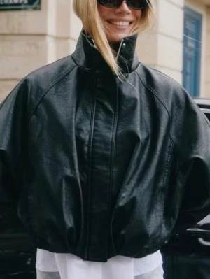 Oversized svart skinnjacka - Säljer en oversized svart skinnjacka med hög krage och dragkedja framtill. Jackan har breda ärmar och en avslappnad passform som ger en cool och modern look. Perfekt för dig som vill sticka ut med en trendig och edgy stil. Säljer då jag köpte flera jackor för att testa !