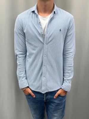 Ralph lauren skjorta | Knit Oxford  - Skick: Mycket bra utan defekter  Färg: Ljusblå/vit  Storlek: L  Nypris: 1600SEK  Passform: Modellen är 185 cm och väger ca 75 kg och den sitter bra  Fraktar oftast samma eller nästa dag 📦