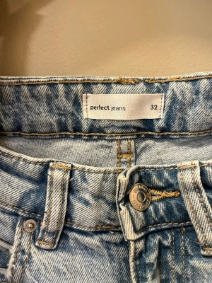 Ljusblå raka jeans  - Säljer ett par ljusblå jeans från Gina tricot i rak modell med hög midja. Jeansen har klassiska fem fickor, bälteshällor och knappgylf. Materialet är denim i bomull och de har en snygg tvättad look som passar till allt.