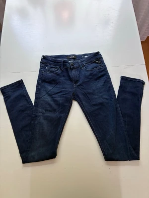 Mörkblå Repley jeans  - Säljer ett par mörkblå skinny jeans med klassisk femficksdesign och smal passform. Jeansen har normal midja och är tillverkade i stretchigt denimtyg för extra komfort. Perfekta för dig som gillar en slimmad look.