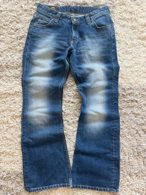 Lee bootcut Jeans - Lee BOOTCUT Jeans🙌🏻👖  Säljer dessa skitsnygga Jeans frän Lee. Riktig byxor som passar ihop med vilket plagg som helst. Otroligt bra skick och inga slitage eller synliga tecken på användning. Vid övriga funderingar, hör gärna av er!!  Laid out liggandes (Mått liggandes) Midja: 39 cm Längd: 99 cm nedre bredd (benöppningen): 24-25 cm  Kondition: 9,5/10✅😁  Storlek: W31 31L  Fraktar samma dag eller dagen efter😁😁  swag rap streetwear baggy vintage skate hiphop y2k affliction archive underground avant g