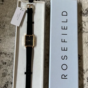 Klocka - Den är från rosefield, hel ny plasten kvar även kartången, bandet går att byta, säljer den just för att skicka tillbaka den va för svårt, jag fick nämligen fel klocka