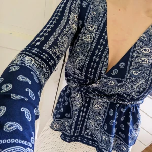 Omlottopp  - Blå paisleymönstrad omlottopp från Gina Tricot i storlek XS. Aldrig använd, nyskick. Tryck gärna på "köp nu".