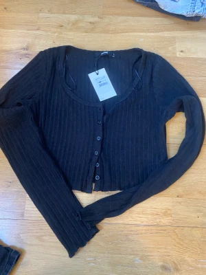 Stickad topp  - Stickad topp med knappar från bikbok. Storlek S. Aldrig använda 