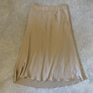 Midikjol i satin från vero moda  - Beige midi kjol i satin från vero moda. Inget slitage, resår i midjan