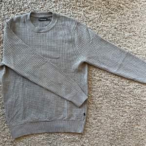 Säljer en grå stickad J.Lindeberg tröja
