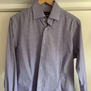 En blå/vit randig skjorta från dressman i stl M. 