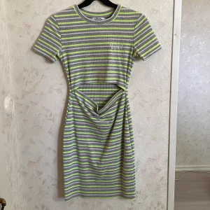 Sommarklänning - Tajt klänning från bershka som är använd fåtal gånger, ingen defekt eller tecken på användning som tex  Text vid vänstra bröstet ”NNO FILTER NEEDED” 