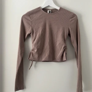 Långärmad tröja - Tröjan är från Nelly och har knytte i sidorna, sitter jättebra