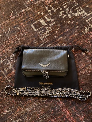 Zadig Voltaire väska  - Säljer nu min fina Zadig Voltaire väska då den inte kommer till användning. Modellen Rock Nano. Den är använd sparsamt ett fåtal gånger. Den är i bra skick och har inga defekter. Äkthetsbevis och kvitto kan fås privat. Nypris: 2900kr. Lilla modellen. 