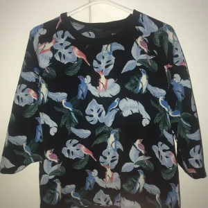 Monki - Flower - Färgglada färger på en kolsvart bakgrund och en ännu mörkare modell.