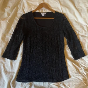 Svart broderad Tröja - Svart broderad tröja med genomskinliga trekvarts ärmar. Tröjan är urringad och helt ny.