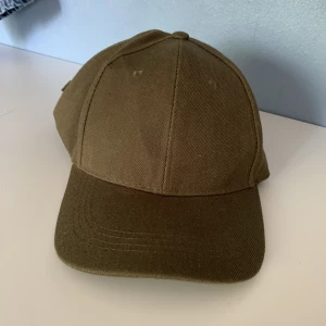 Keps - Olivgrön keps som är oanvänd.