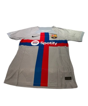 Barcelona - En Barcelona tröja i storlek M som är grå. Den är perfekt passande och av hög kvalitet. Dess andningsförmåga gör den idealisk för både matcher och träning. 