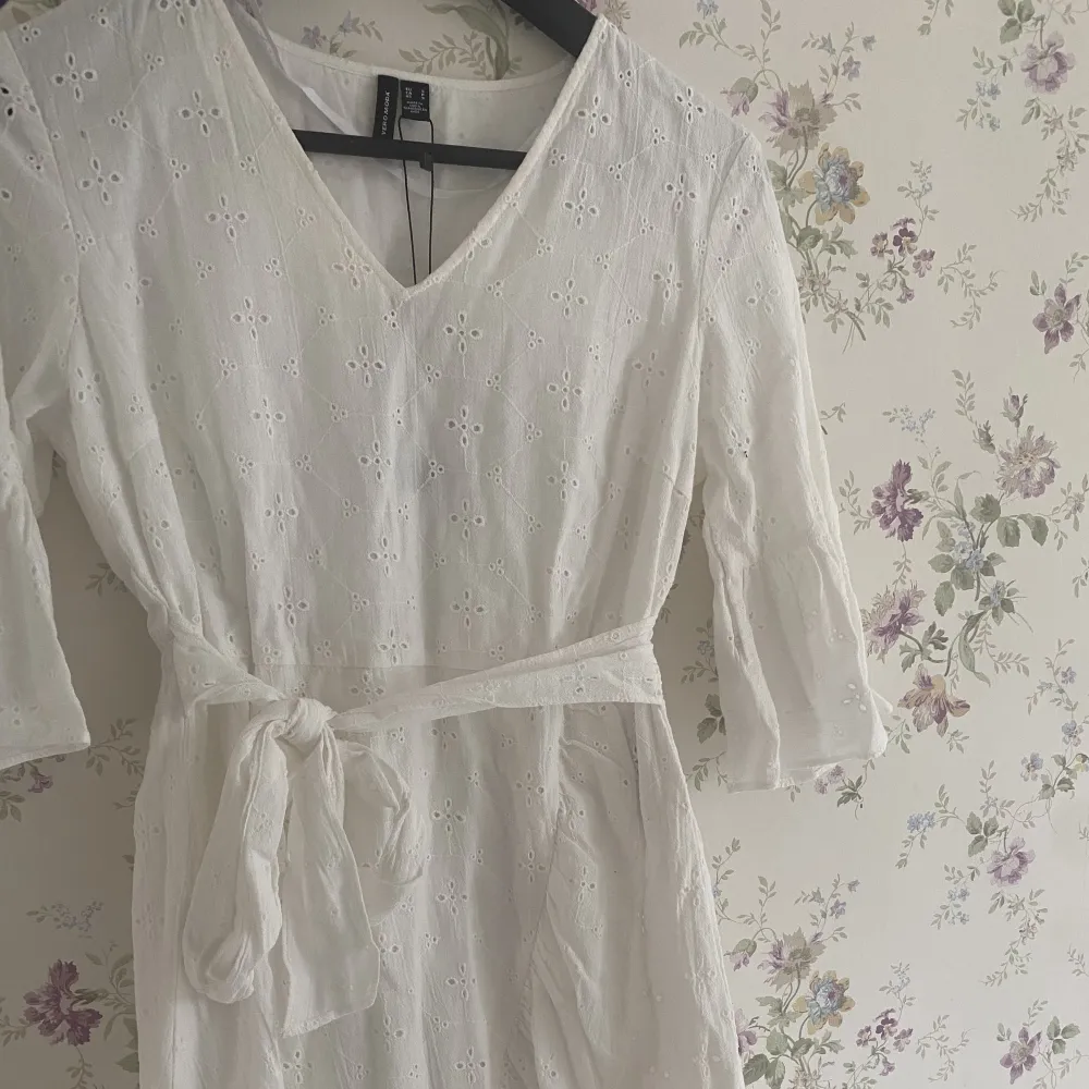 En perfekt vit klänning till sommaren. Den är i mycket bra skick, helt oanvänd.  Klänningen är V-ringad och har ett fint mönster. 100% bomull. . Klänningar.