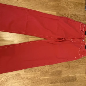 Röda byxor med flammor - Sköna jeans som jag köpte secondhand för 100kr och har använt ungefär 3 gånger. Är ganska oversized och passar en S i midjan. 