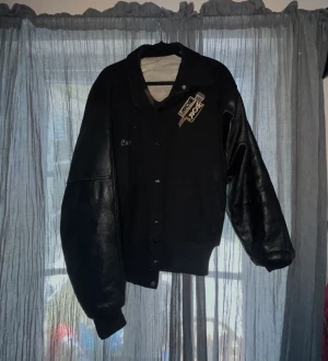 Jacka - Tuff varsity jacka med strukturerade läderfärgat🖤🖤 Jackan har guldig text/detaljer framtill och på ryggen. jackan köptes på ”pop Stockholm” för ca 2 år sedan för 1100kr, skriv för fler bilder💕