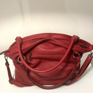 Röd rymlig handväska - Fin röd shoulder väska i nästintill nyskick i slittålig läderimitation. Silver och svarta detaljer, flera fack och dragkedja inuti och utanpå och en avtagbar axelrem❤️ Köpt för 800 kr