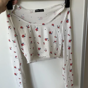 Blommig vit kroppad tröja  - Vit blommig kroppad tröja från Shein. Bra skick. Storlek XS. För liten för mig.
