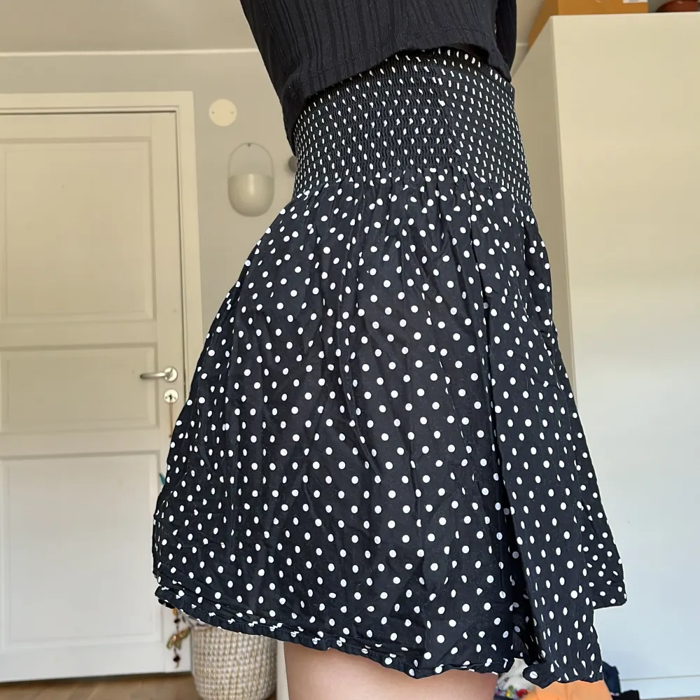 Mammas gamla svarta kjol med prickar på. Lappen är avklippta men den är köpt på h&m. Utöver det så är den i nyskick. Storleken uppskattas vara en XS.. Kjolar.