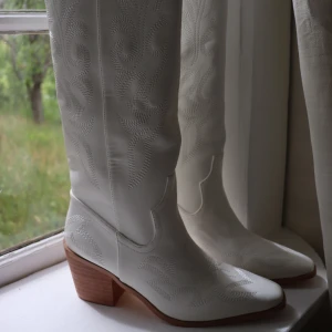 Cowboyboots - Vita cowboyboots som aldrig har använts. De är knähöga. Ordinarie pris 900! Säljer för att de inte passade mig. 