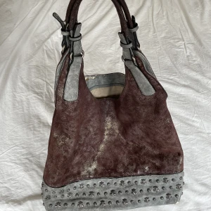 Brun väska  - Brun väska med silver detalj plus gulskimrigr tyg🤎🤎 En av mina favoritväskor. Sliten på insidan vilken man ser på bilderna