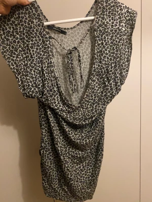 Leopard t shirt - Leopard mönstrad t shirt, med ett band som kan knytas antingen där fram eller där bak. Använt några gånger men fri från fläckar osv. 