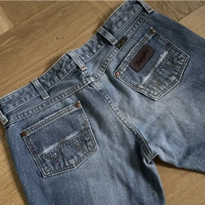 Wrangler jeans (low waist) - Säljer dessa jättefina jeansen då dom tyvär är för små för mig. Färgen är superfin då dom ser lite vintage ut💕