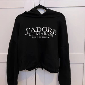 Svart hoodie  - Svart hoodie med tryck och knyt runt midjan från Ginatricot, säljer denna då jag tyvärr inte använder den. Passar stl xxs-m.